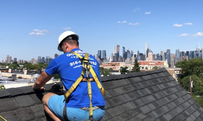 Roof Repair Westchester County NY Roof repair in Westchester County NY - B&W Group roofer on a shingle roof with the Manhattan skyline behind