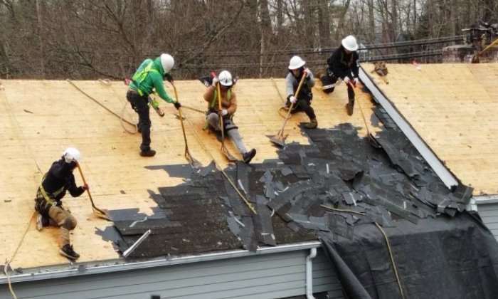 Roof Replacement Westchester County NY Roof replacement in Westchester County NY - B&W Group crew tearing off an old roof down to the deck